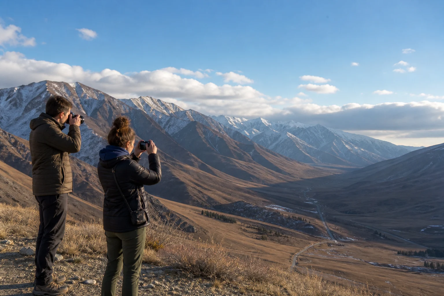 International travelers taking landscape photographs from a safe mountain viewpoint in Xinjiang